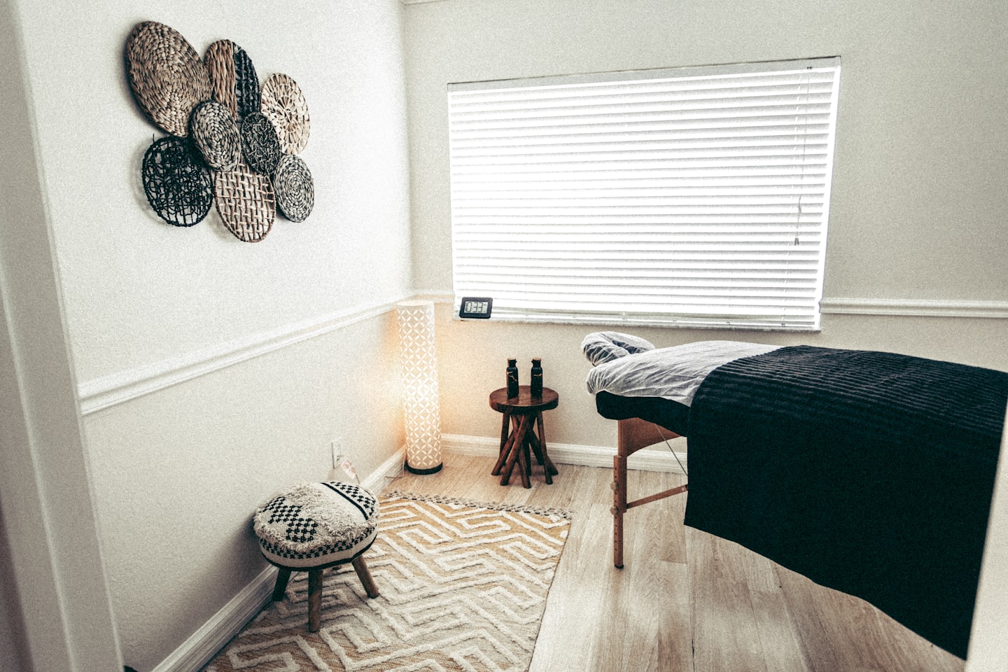 Empty massage bed in a tranquil therapy room with wood floors.