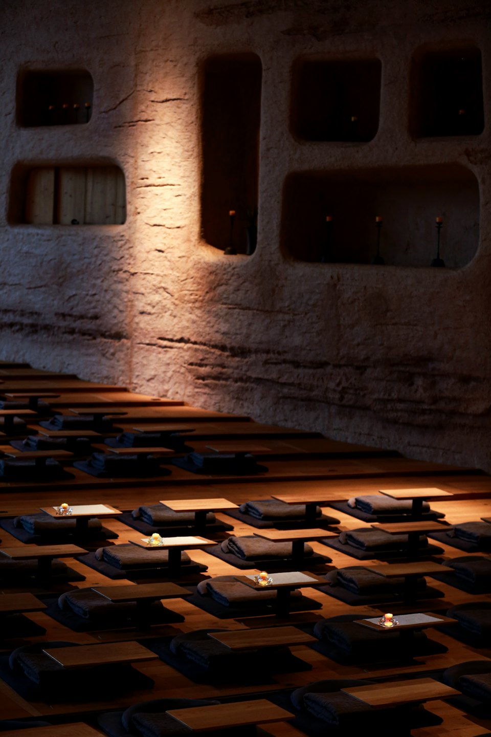 Empty meditation room with cushions and candles on the floor.